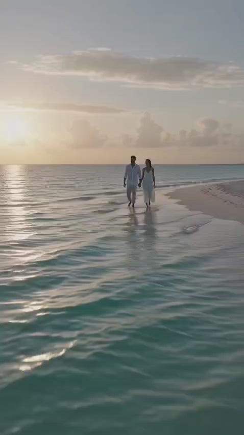 Couple walking on beach at sunset